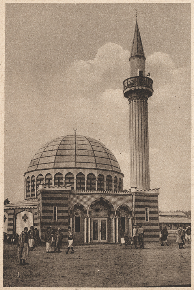 Sepia photograph of the exterior of a domed mosque with a minaret