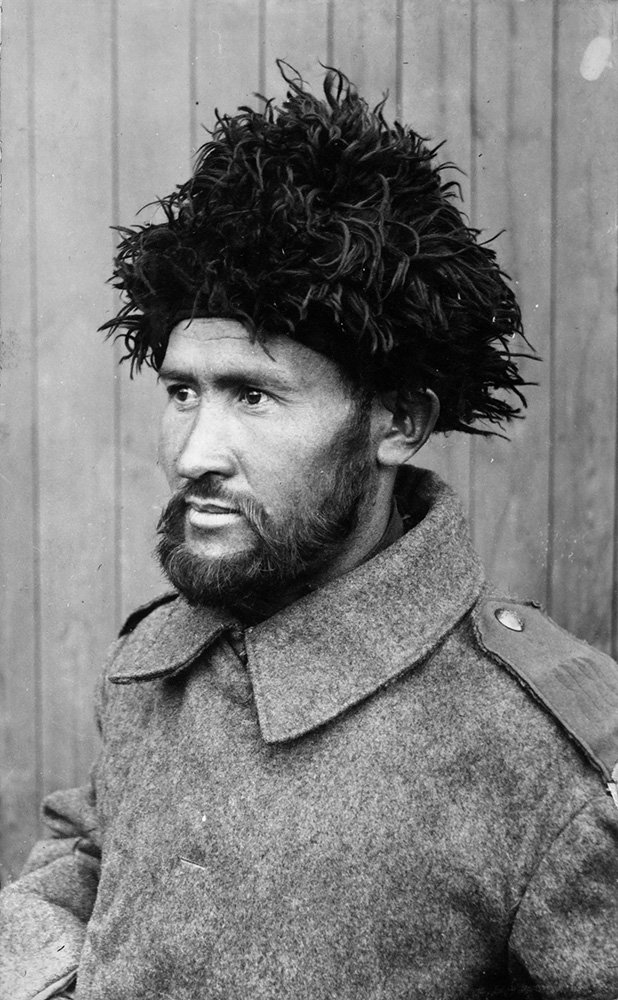 Black and white portrait photograph of a bearded man wearing a fur hat