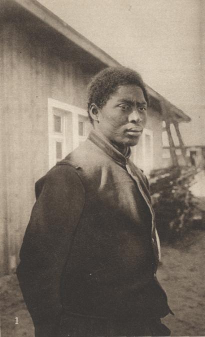 Sepia photo of a Black man wearing a simple coat with scarring on his cheek.